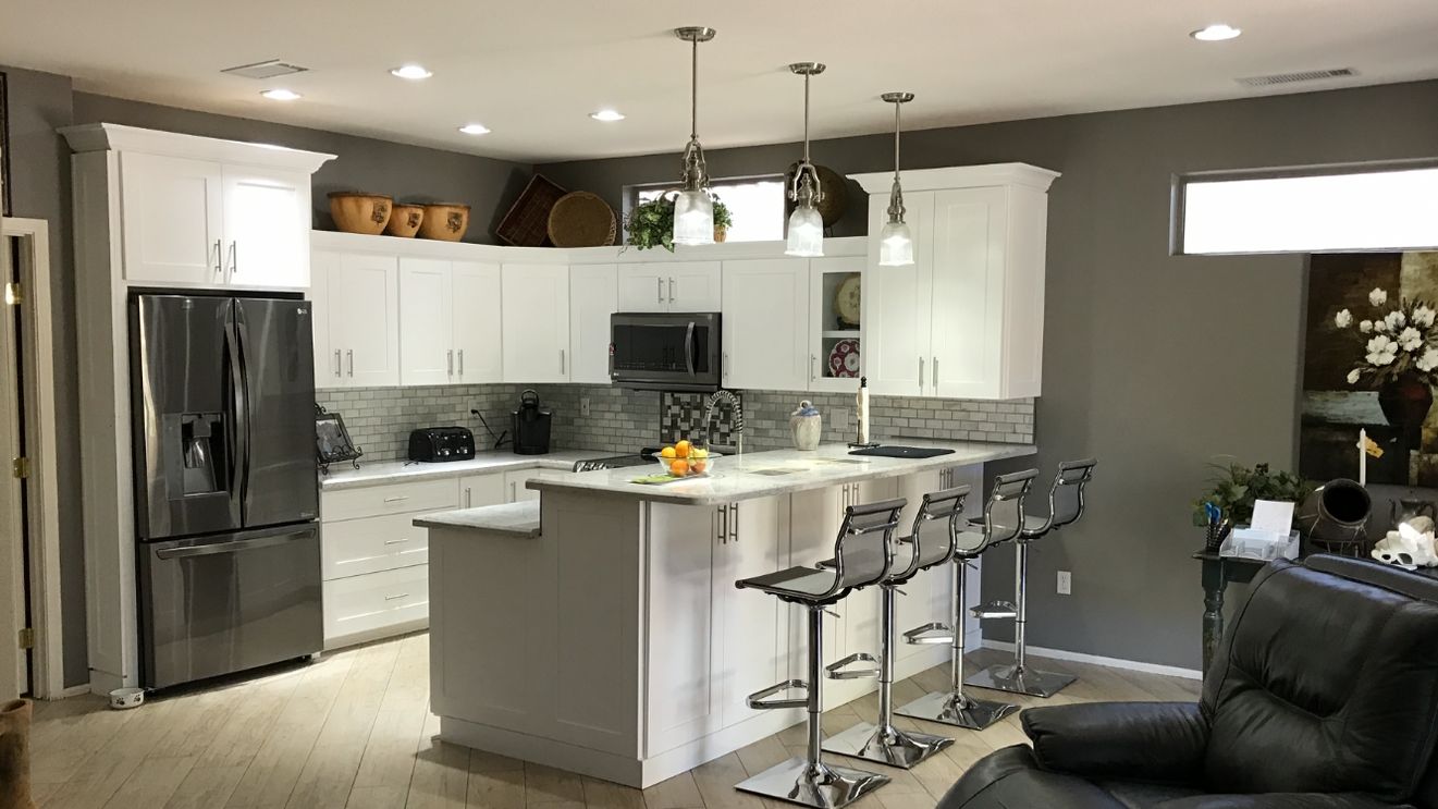 White kitchen remodel with granite countertops and a tile backsplash